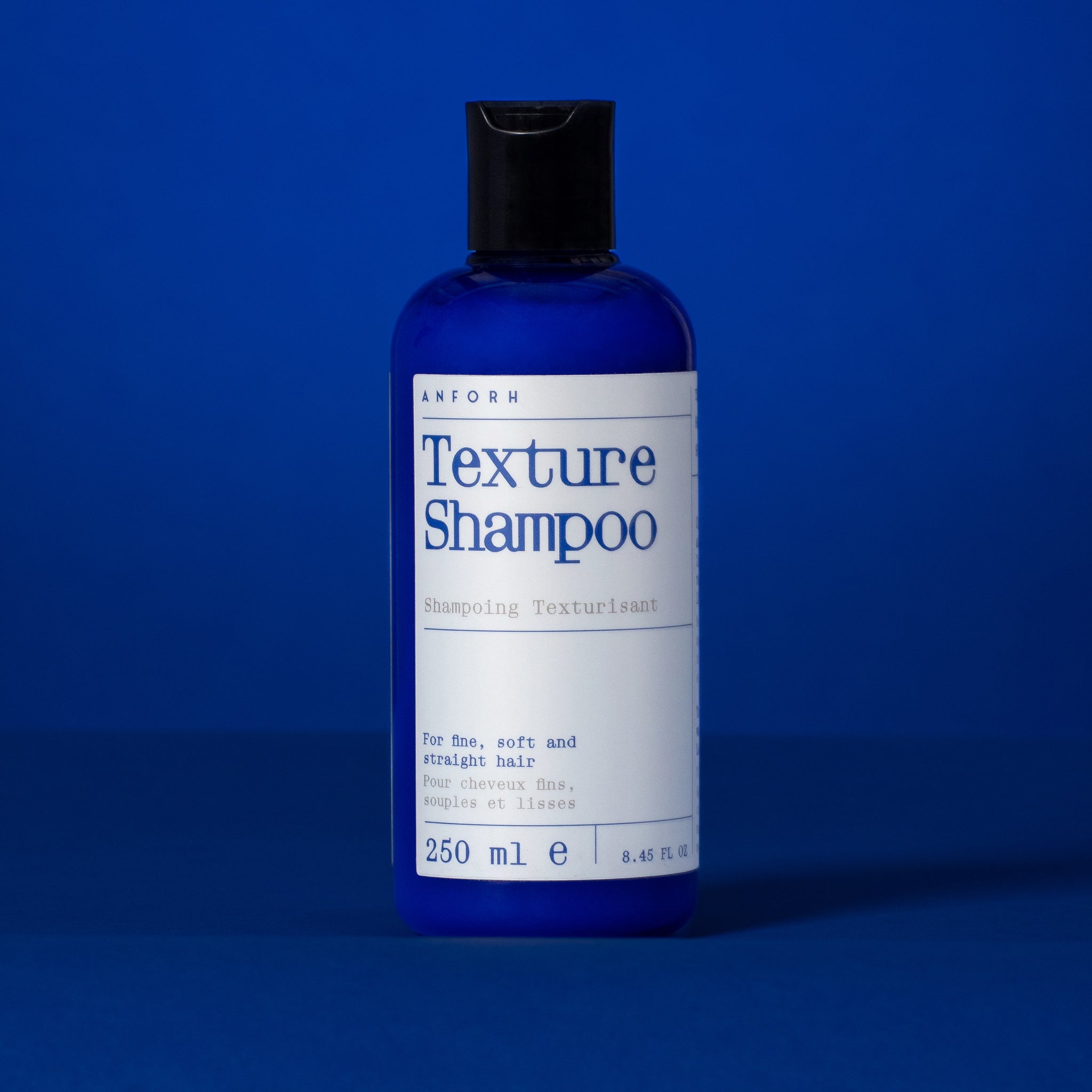 Blue plastic bottle of Anforh Texture Shampoo against a blue background